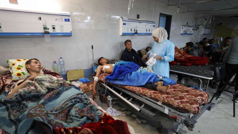 Palestinians who were wounded in Israeli fire while waiting for aid, according to health officials, lie on beds at Al Shifa hospital, amid the ongoing conflict between Israel and Hamas, in Gaza City
