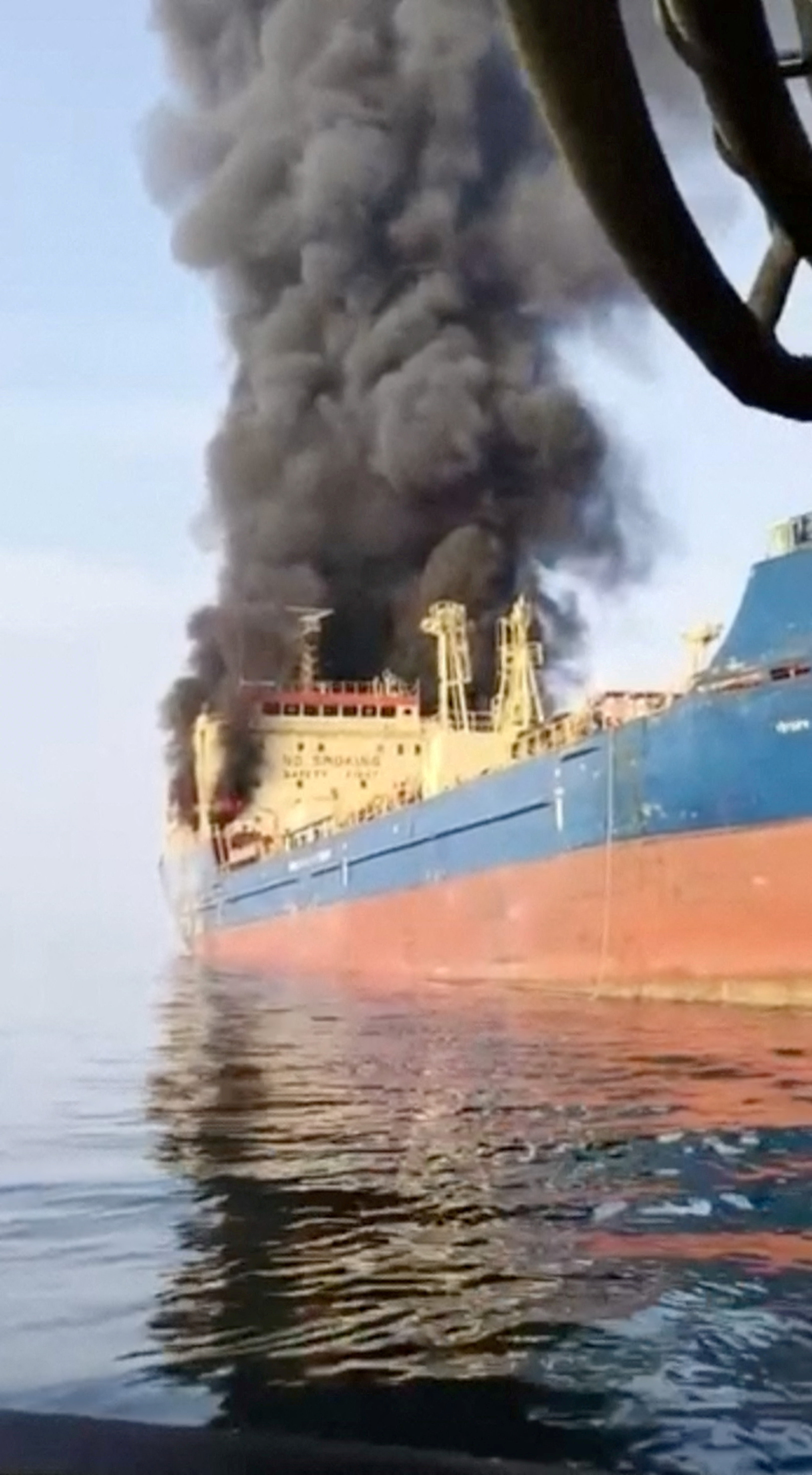 Smoke billows from an oil tanker under U.S. sanctions, that was hit off Oman's Musandam peninsula, in this screen grab from a video