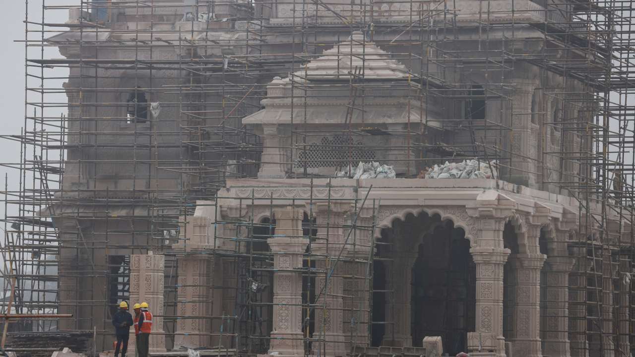 Workers stand in front of the under construction site of the Hindu Ram Temple in Ayodhya