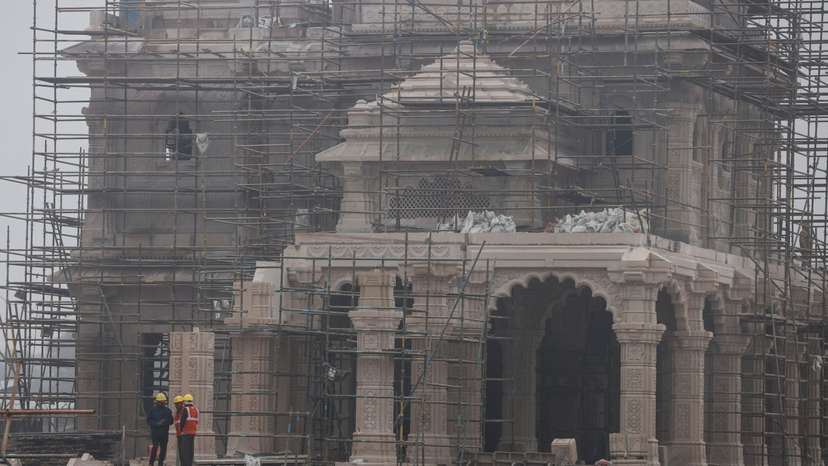 Workers stand in front of the under construction site of the Hindu Ram Temple in Ayodhya