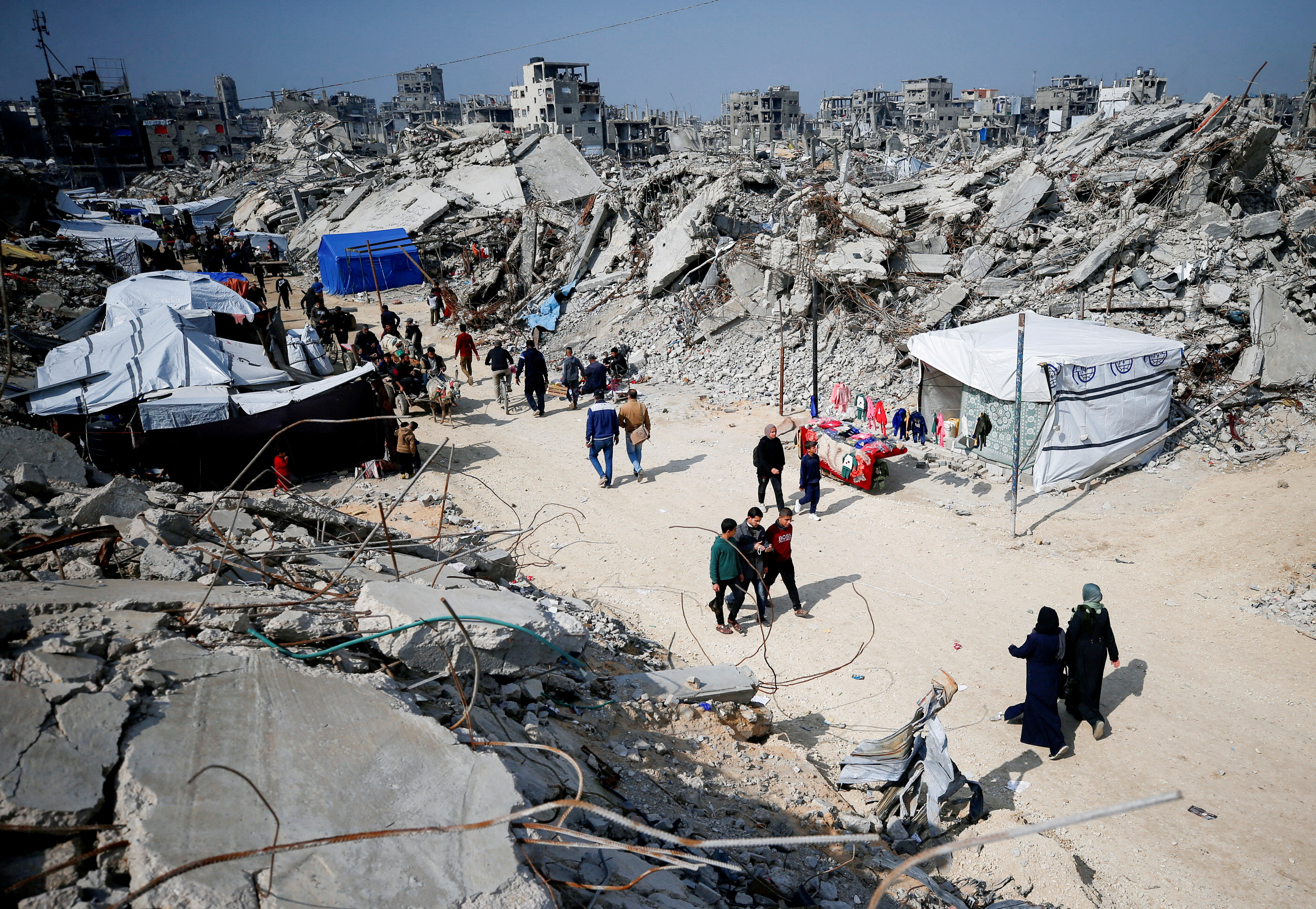 Palestinians gather around rubble of buildings destroyed during the Israeli offensive, in northern Gaza