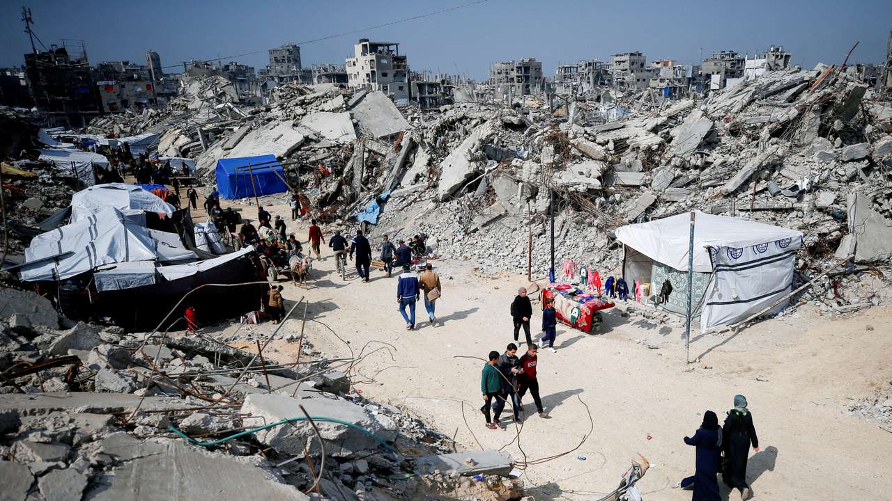 Palestinians gather around rubble of buildings destroyed during the Israeli offensive, in northern Gaza