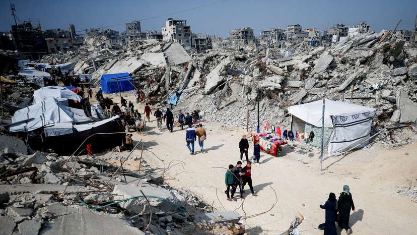Palestinians gather around rubble of buildings destroyed during the Israeli offensive, in northern Gaza