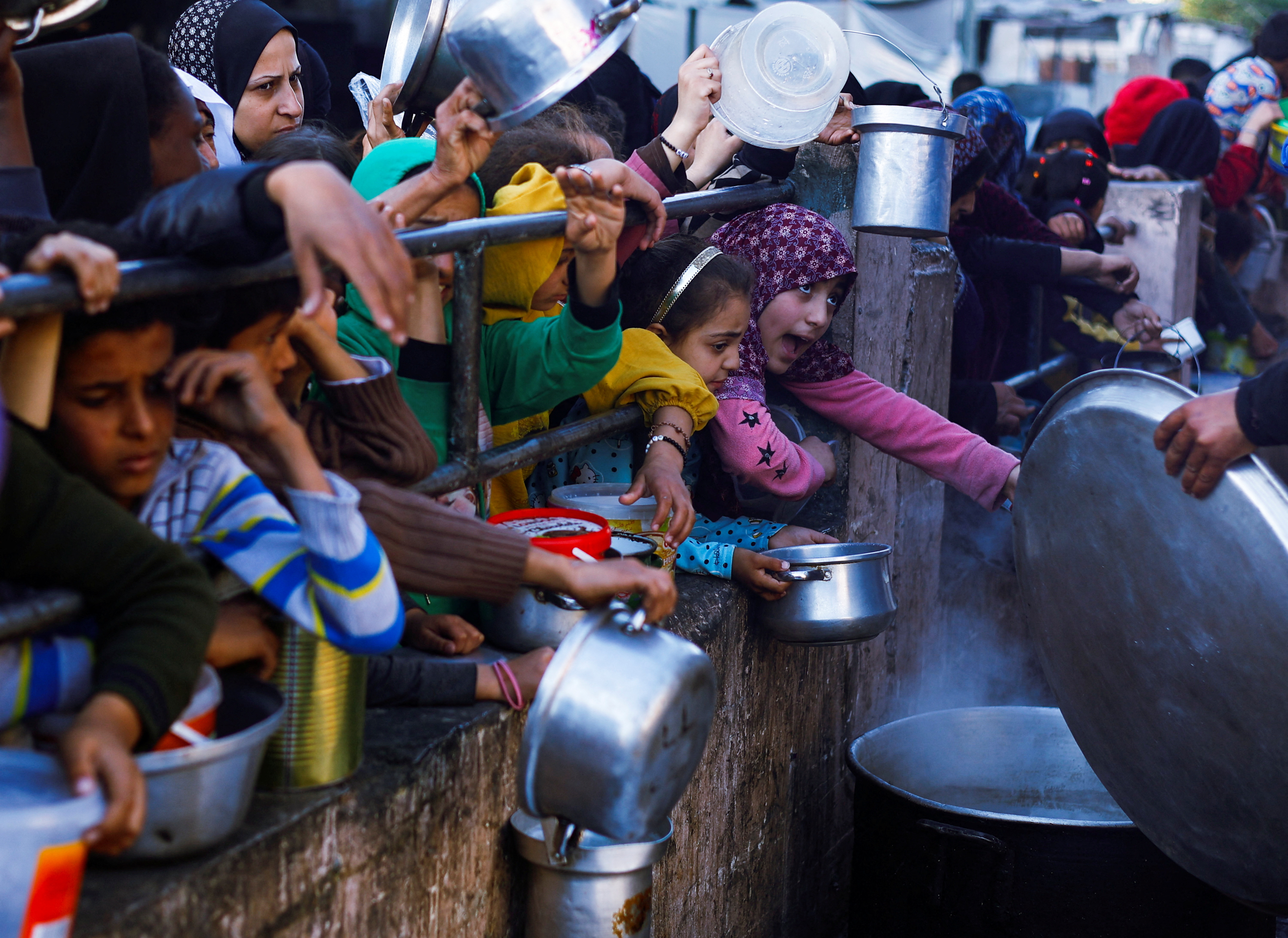 Palestinians wait to receive food during Ramadan, in Rafah
