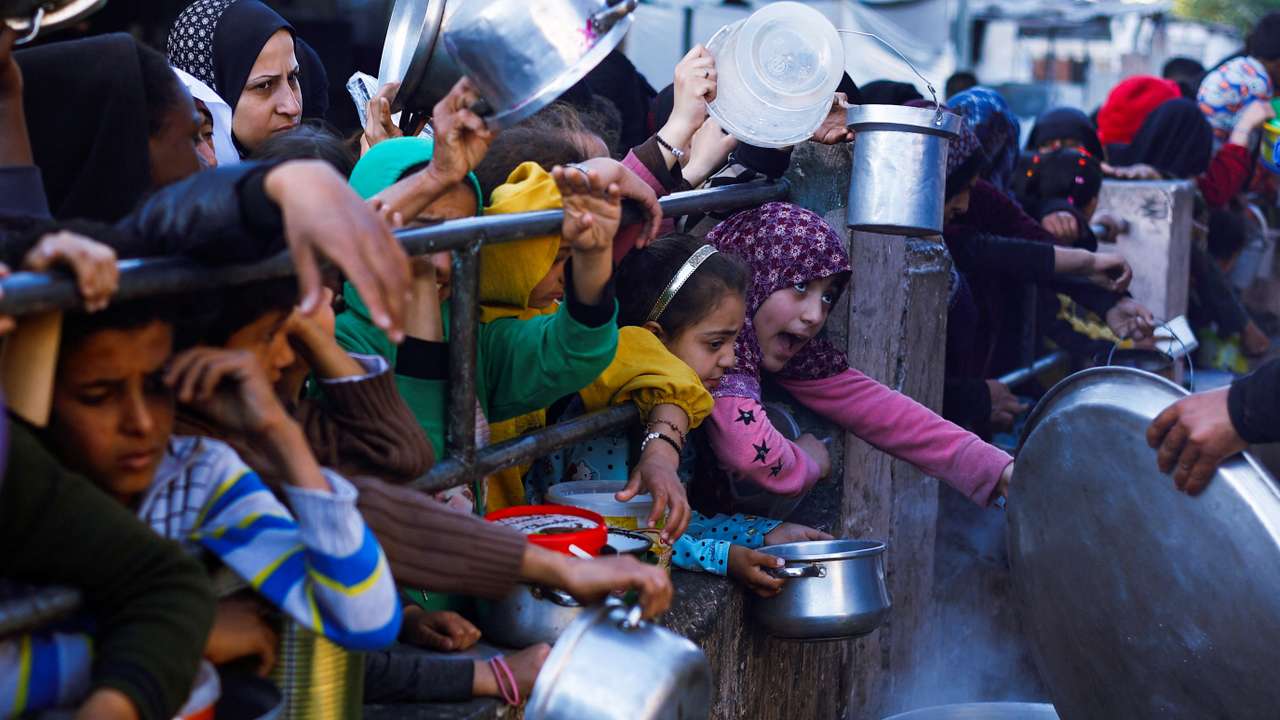 Palestinians wait to receive food during Ramadan, in Rafah