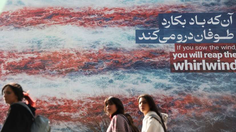 Iranian women walk past an anti-U.S. billboard in Tehran