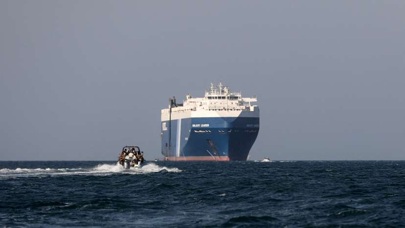 FILE PHOTO: Boat carrying people sails near the Galaxy Leader commercial ship, seized by Yemen's Houthis last month, off the coast of in al-Salif