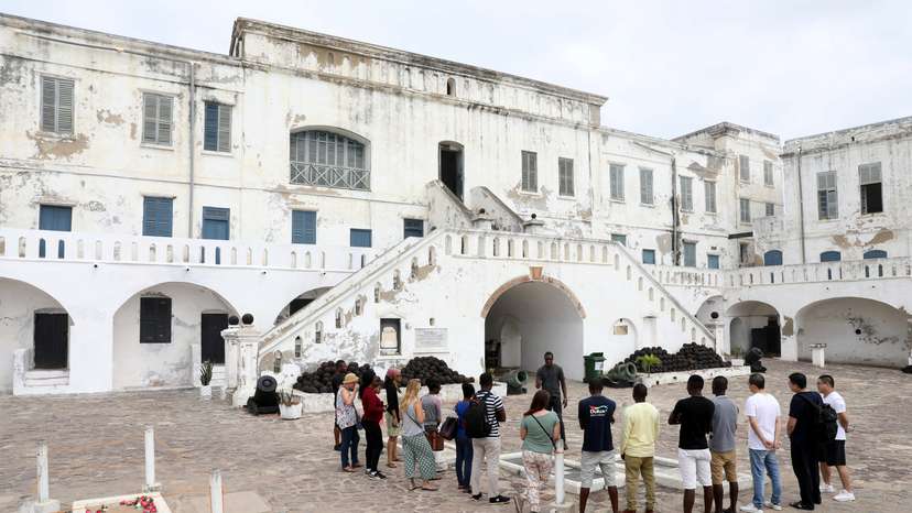Foreign tourists listen to a guide at the Cape Coast Slave Castle