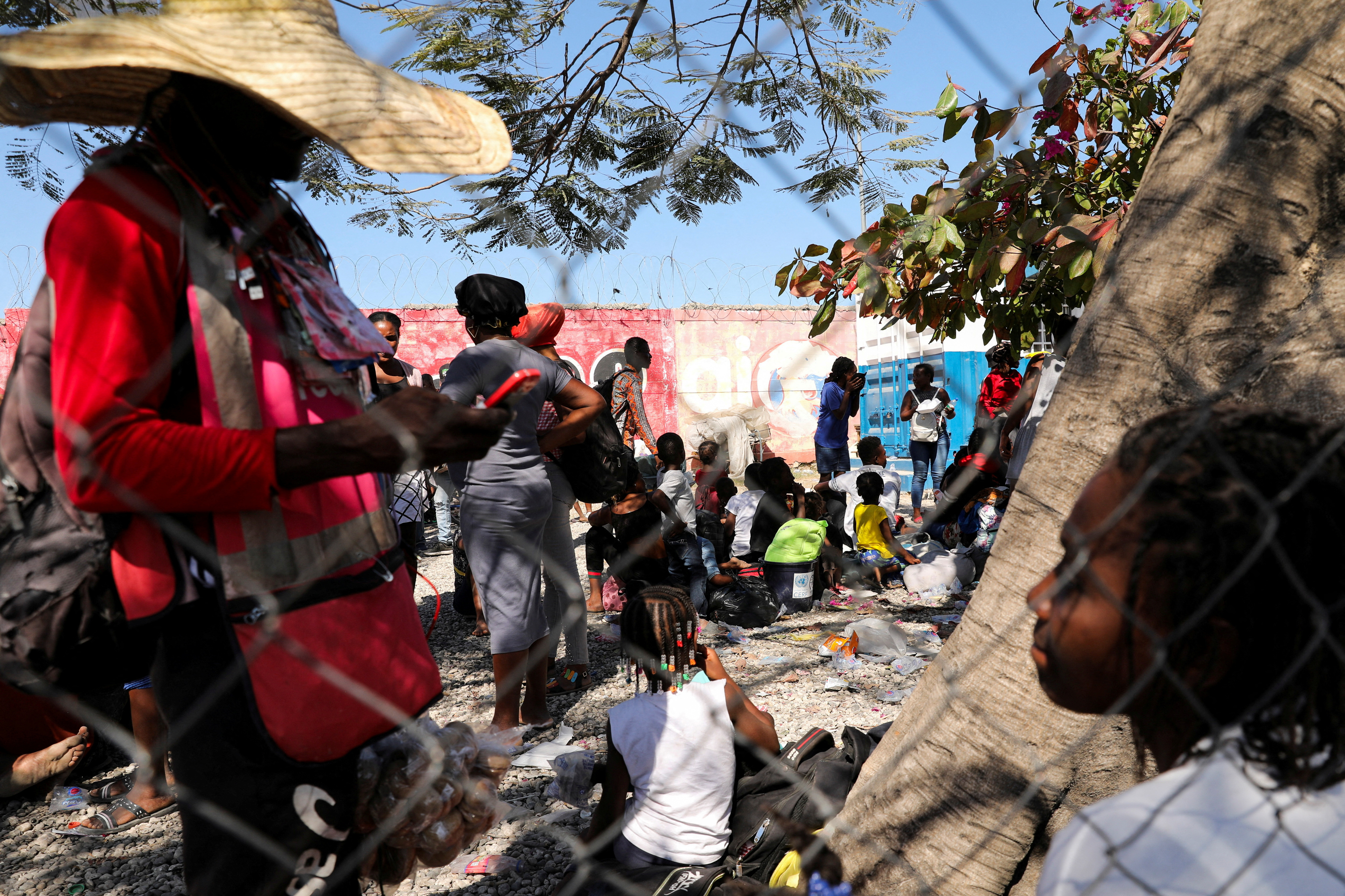 FILE PHOTO: People fleeing violence gather outside a Haitian National Police station, in Port-au-Prince