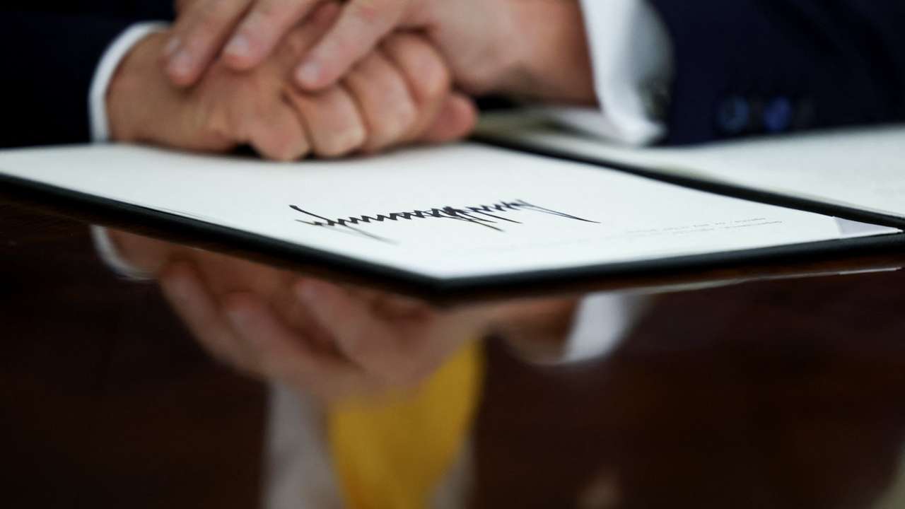 U.S. President Donald Trump signs an executive order in the Oval Office of the White House in Washington