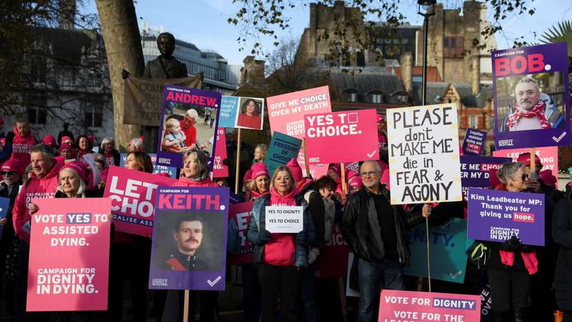 Protestors gather as British lawmakers debate the assisted dying law, in London