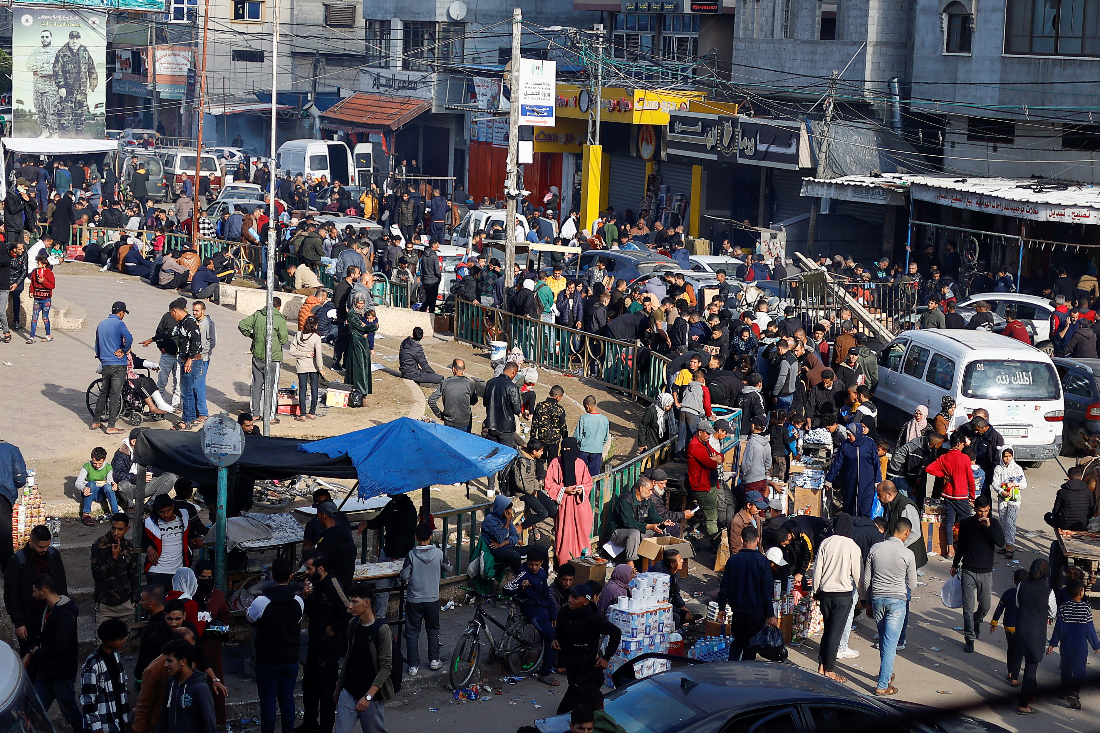 Palestinians shop at a market, in Rafah