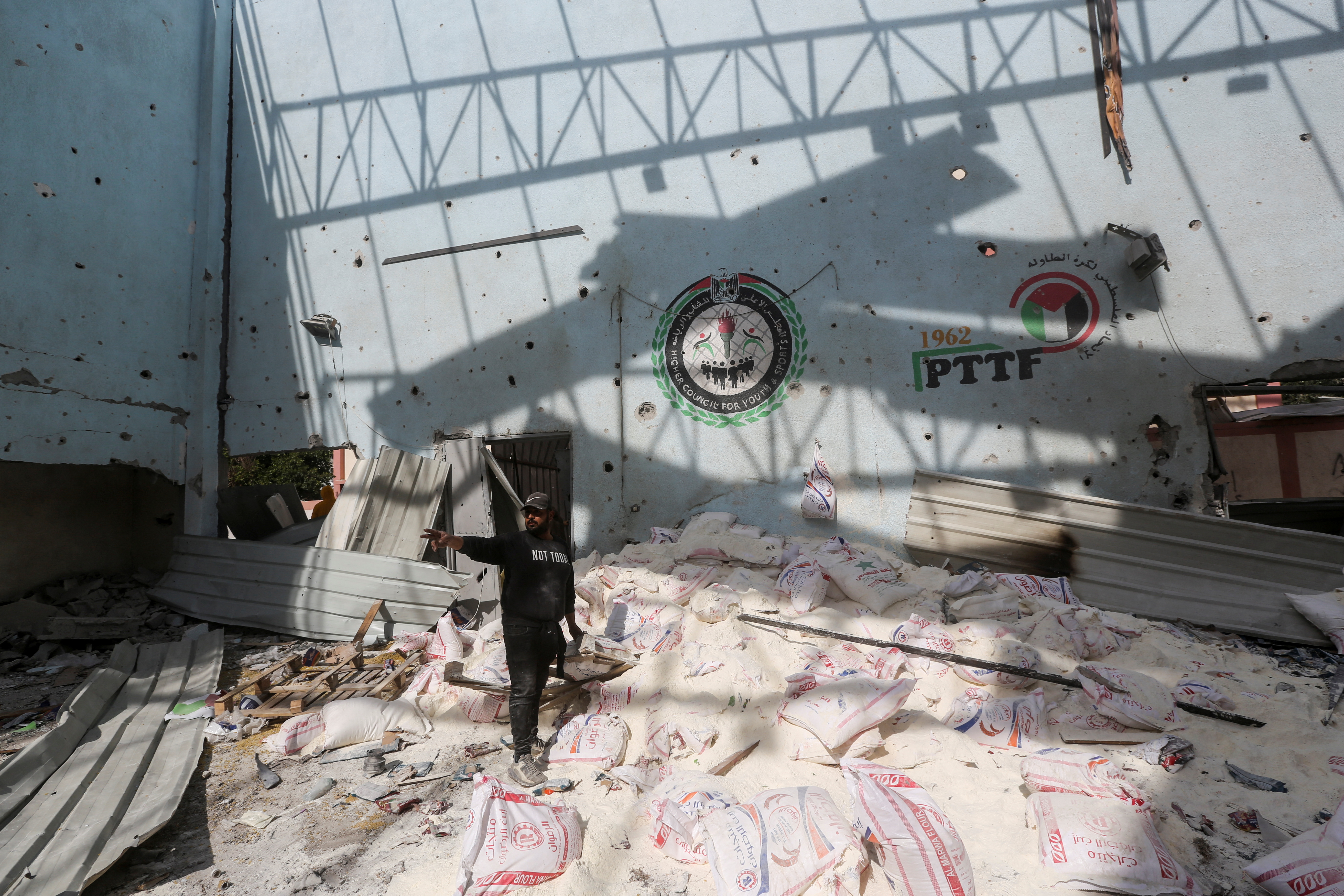 Palestinians inspect the site of an Israeli strike on an aid warehouse, in Al-Nuseirat refugee camp