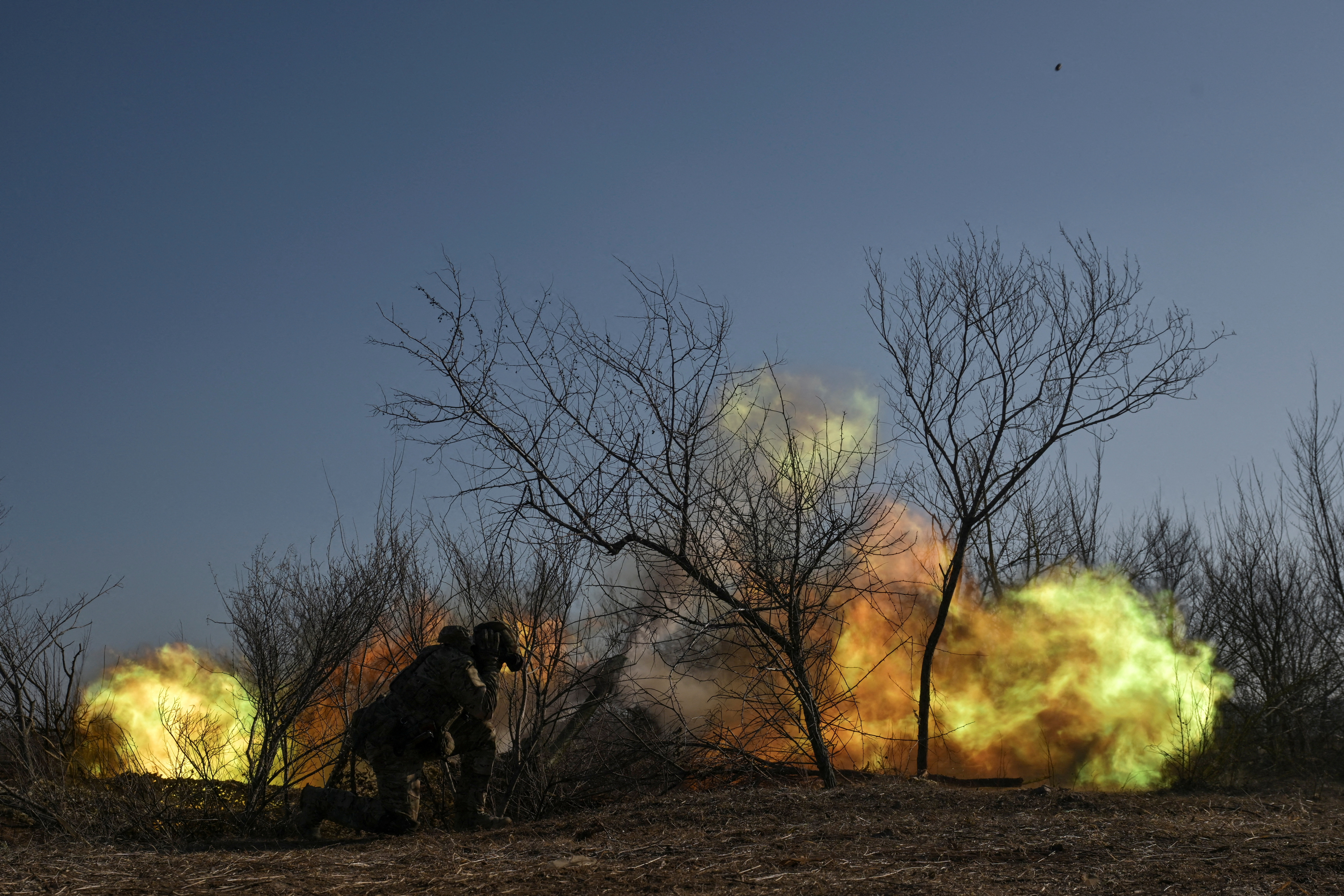 Police officers fire a howitzer towards Russian troops on a front line in Zaporizhzhia region