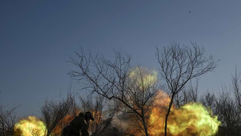 Police officers fire a howitzer towards Russian troops on a front line in Zaporizhzhia region