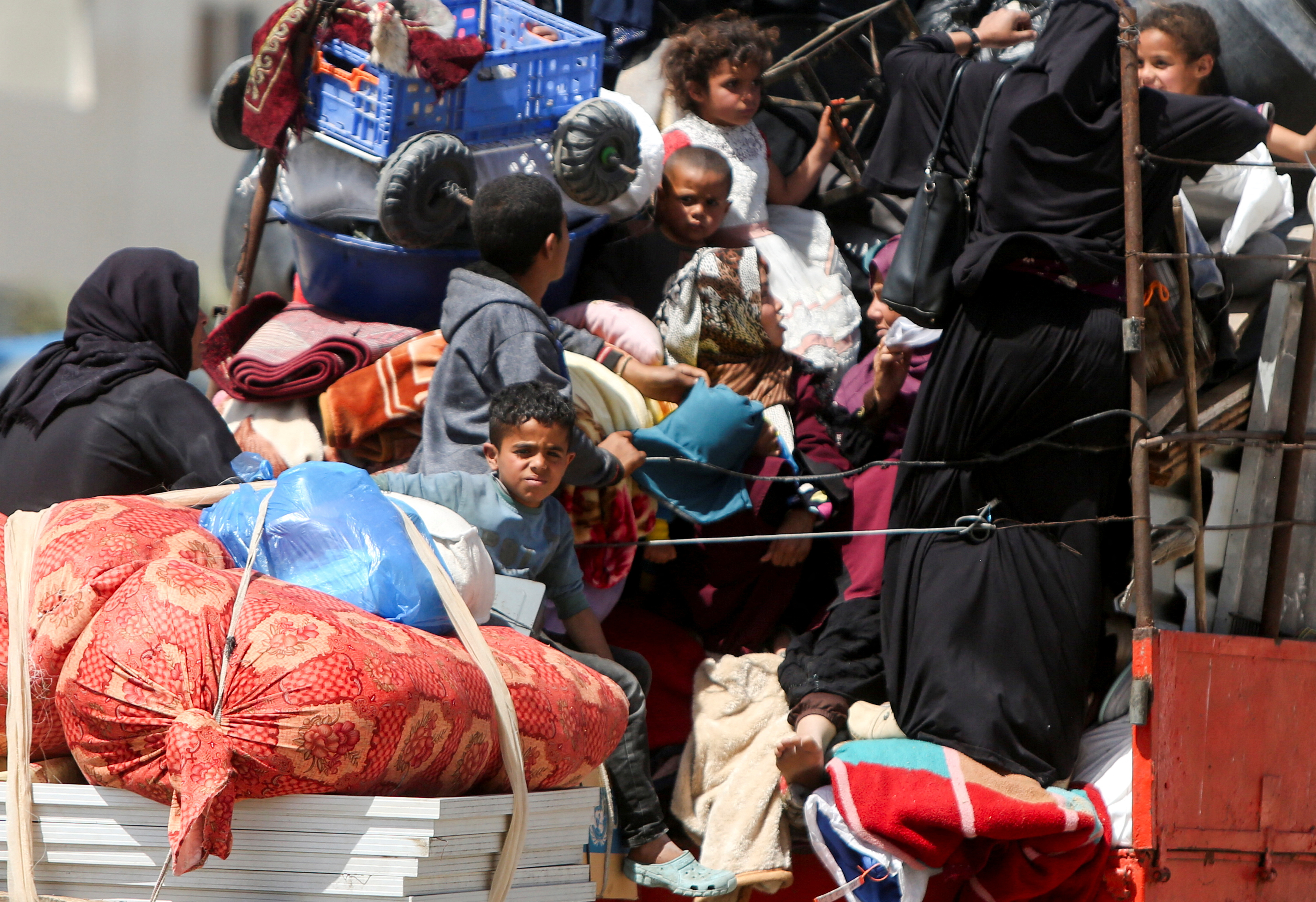 Palestinians make their way after fleeing areas around the southern city of Rafah, following an Israeli evacuation order, in Khan Younis