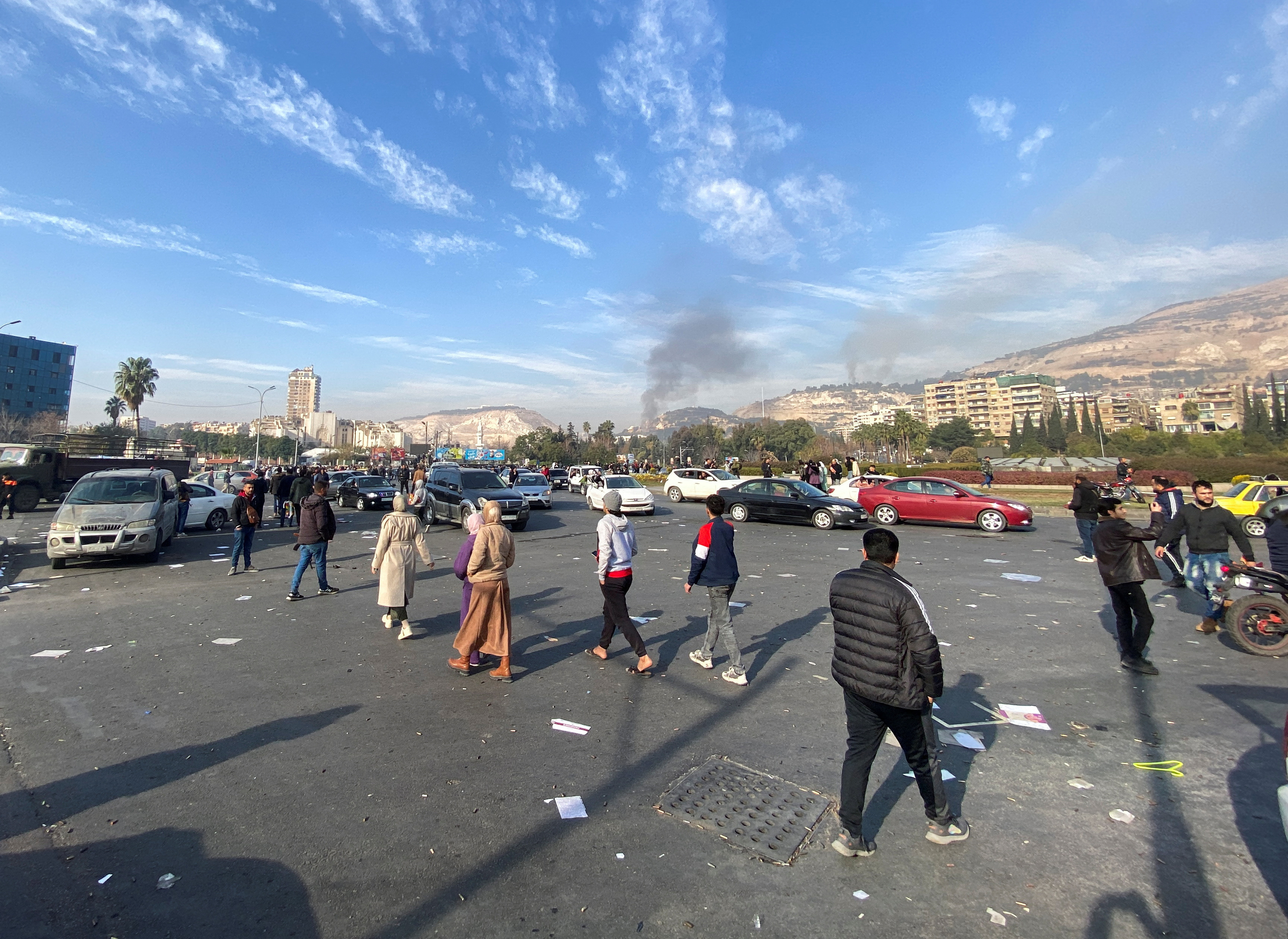 Smoke rises as people gather in Damascus