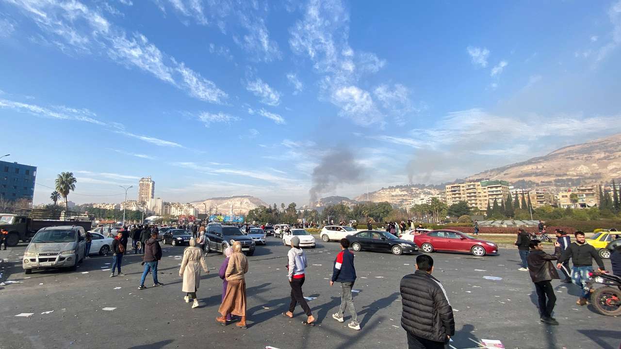 Smoke rises as people gather in Damascus