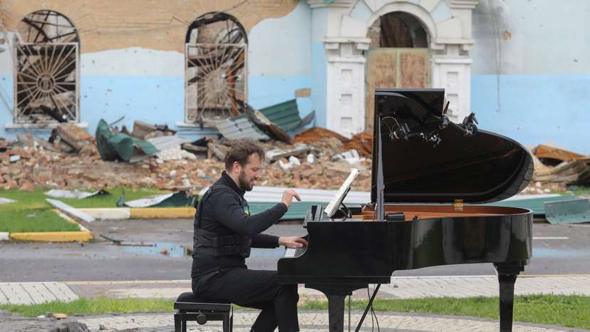 FILE PHOTO: Lithuanian musician Mazintas plays a piano in front of the destroyed Central House of Culture in Irpin