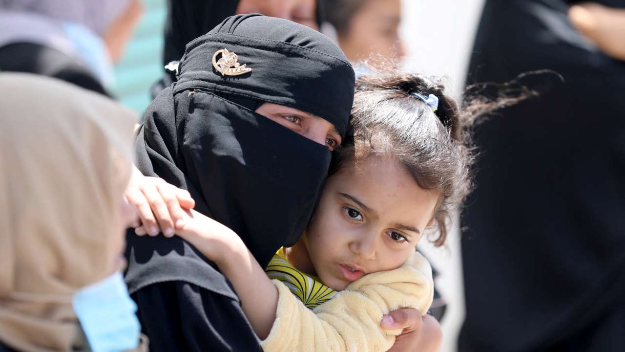 Mourners react as people rebury the bodies of Palestinians killed during Israel's military offensive and buried earlier at Nasser hospital, in Khan Younis