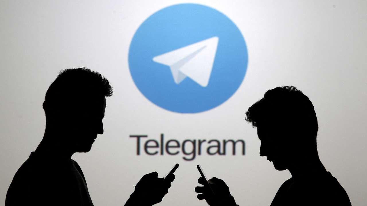 FILE PHOTO: Two men pose with smartphones in front of a screen showing the Telegram logo in this picture illustration taken in Zenica