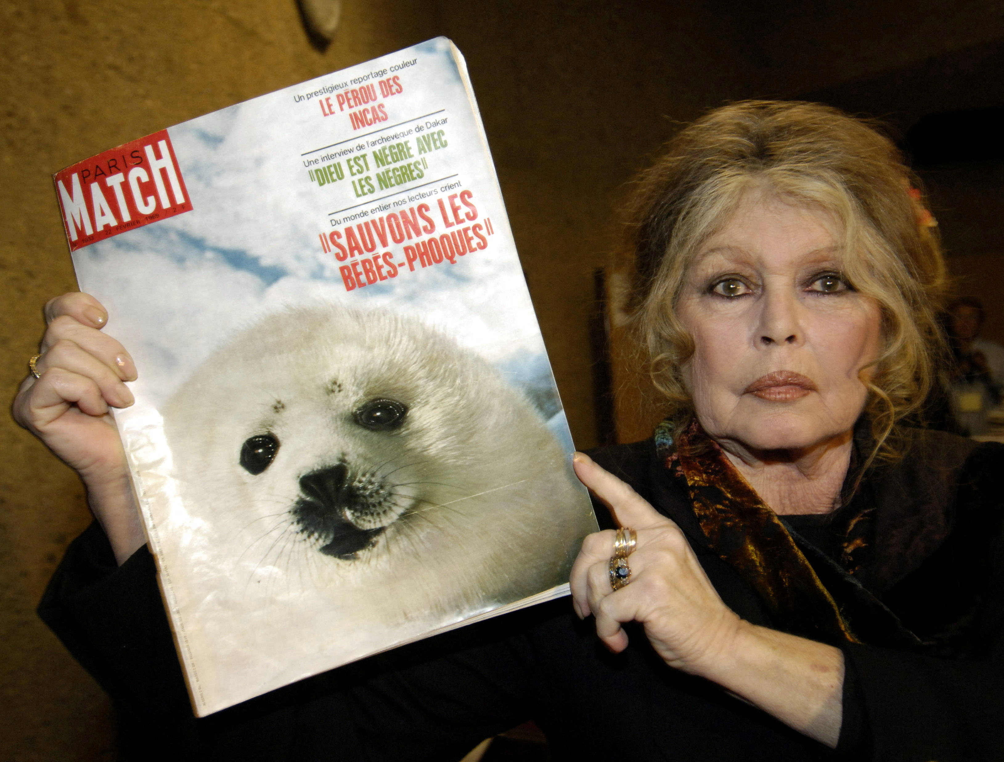 FILE PHOTO: Former French actress Brigitte Bardot displays a 1969 copy of french magazine "Paris Match" showing ..