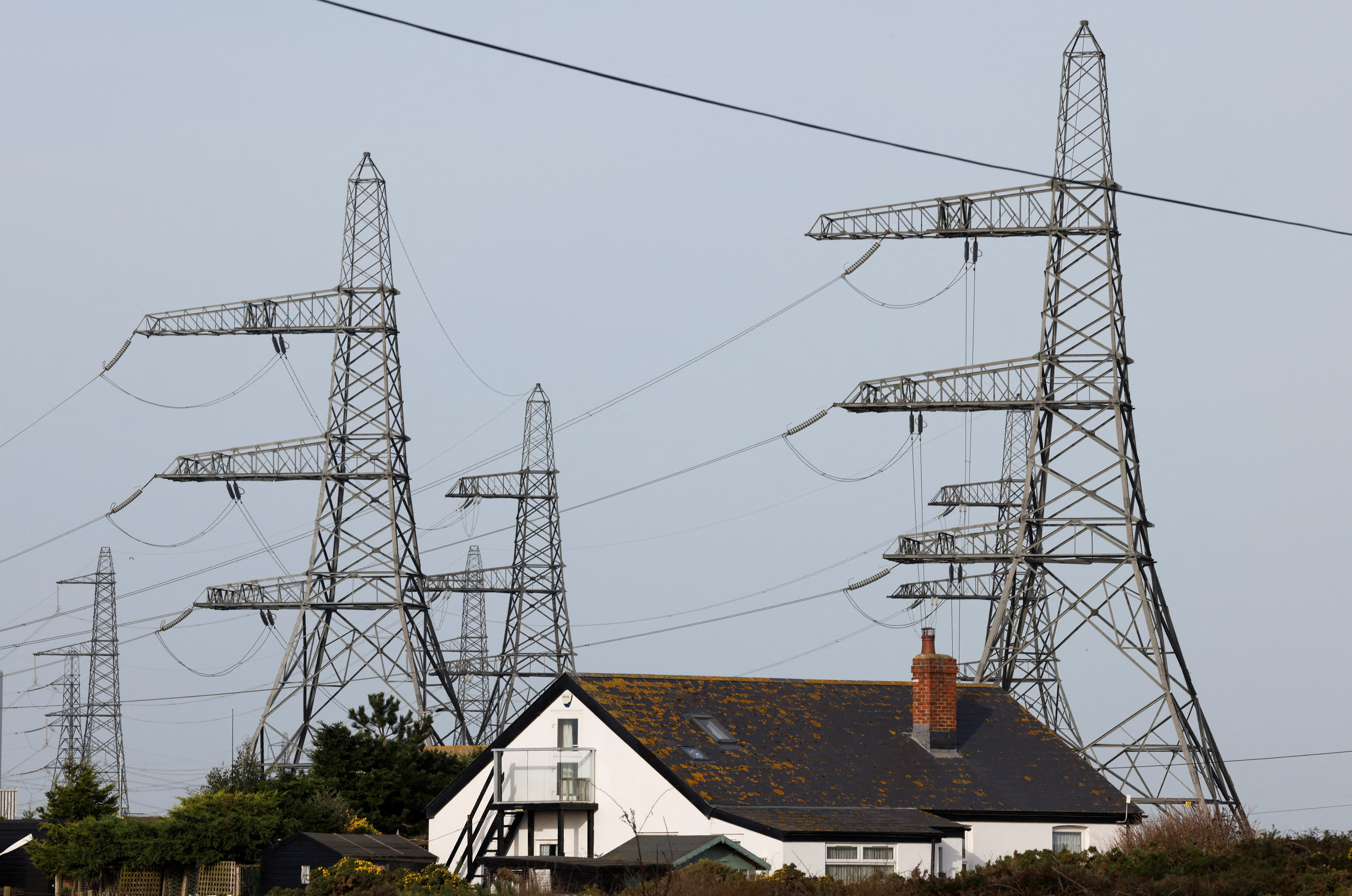 FILE PHOTO: Electricity pylons are seen behind a local house in Dungeness
