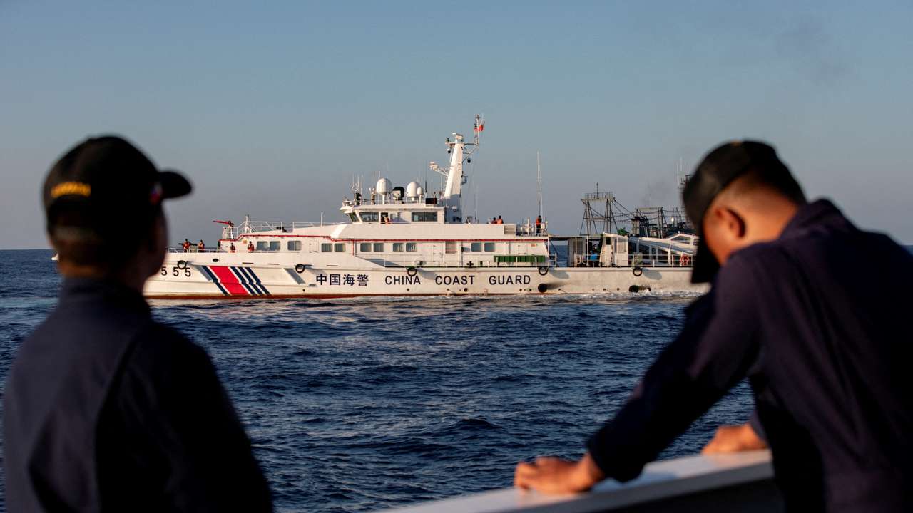 FILE PHOTO: Members of the Philippine Coast Guard stand alert as a Chinese Coast Guard vessel blocks their way to a resupply mission at Second Thomas Shoal in the South China Sea