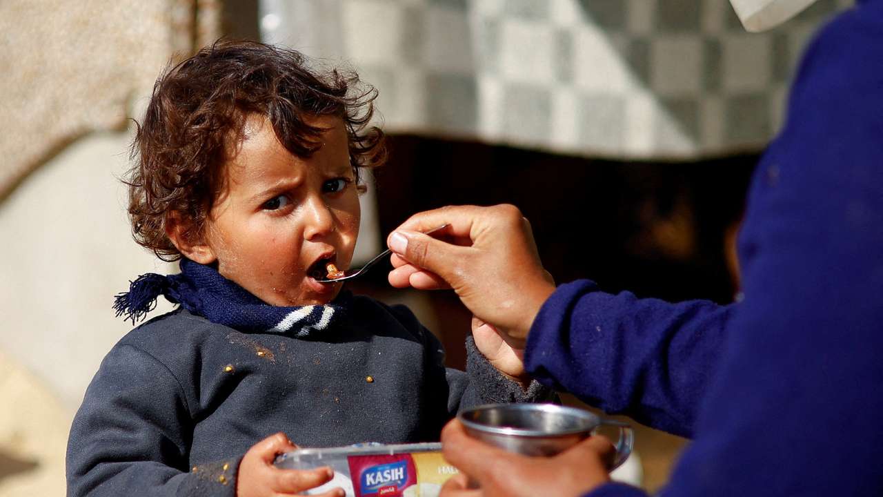 A displaced Palestinian child, who fled due to Israeli strikes, eats, amid the ongoing conflict between Israel and Hamas, in Rafah in the southern Gaza Strip