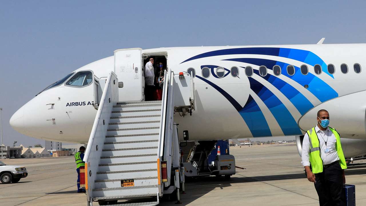 FILE PHOTO: Employee of Luxor's International Airport walks next to an EgyptAir plane, in Luxor
