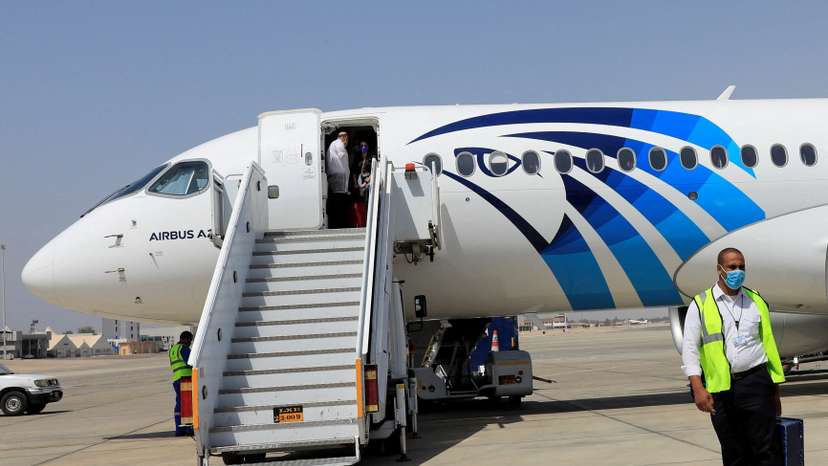 FILE PHOTO: Employee of Luxor's International Airport walks next to an EgyptAir plane, in Luxor