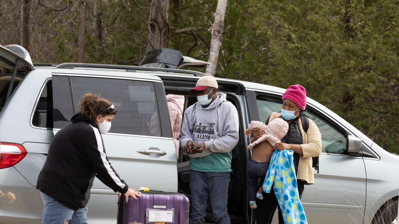 Asylum seekers cross into Canada near a checkpoint on Roxham Road