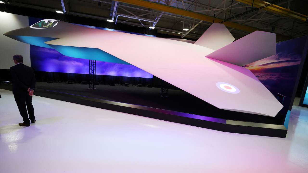 A member of staff stands next to a concept model of the new GCAP (Global Combat Air Programme) 6th generation military jet at the BAE Systems Warton factory in Warton