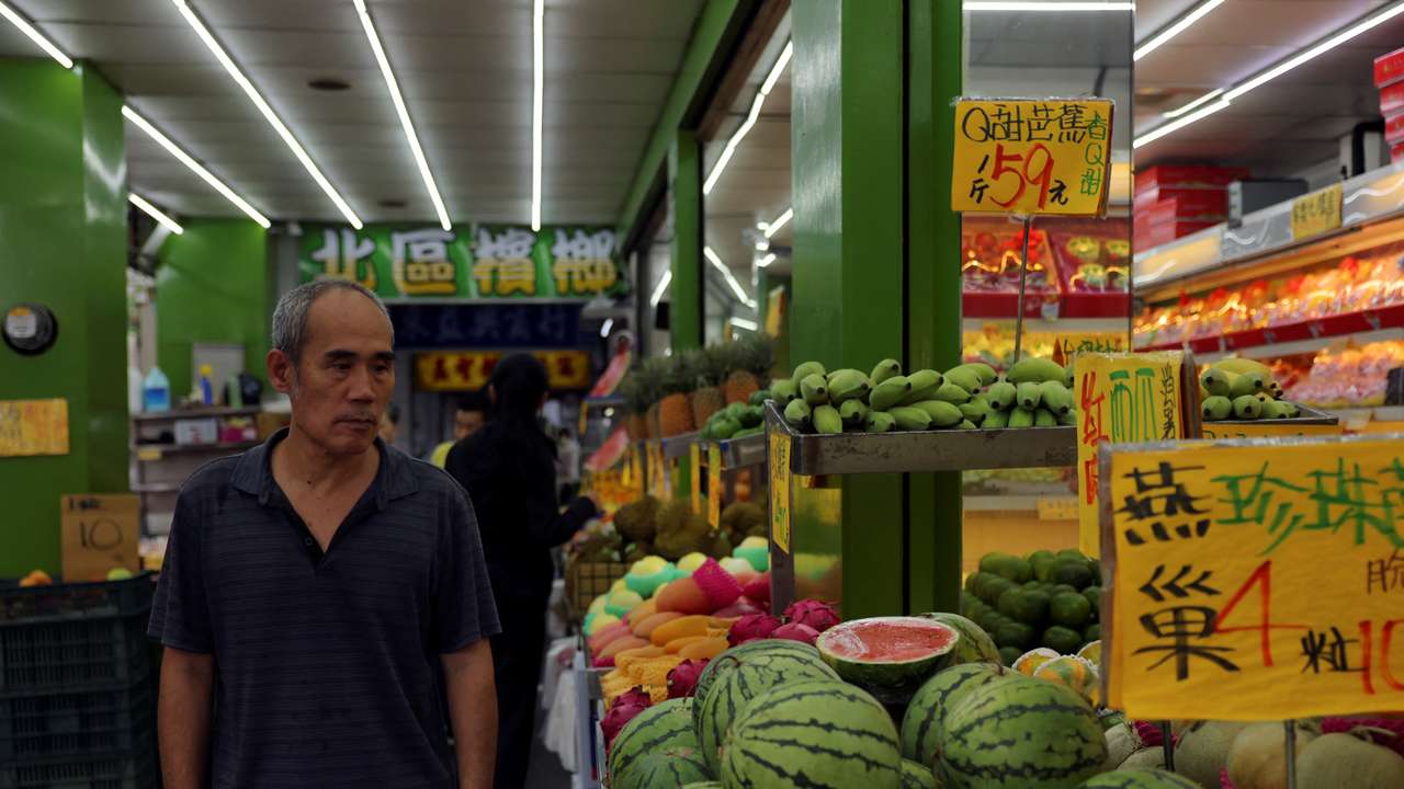 Man walks past a fruits shop in Taipei
