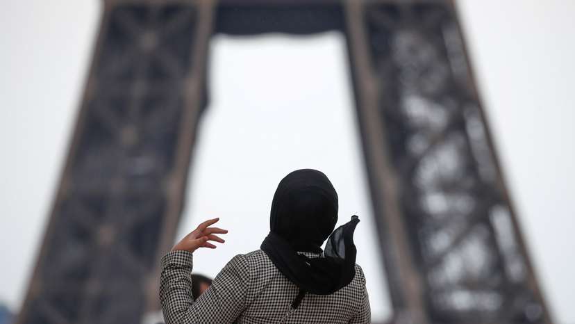 FILE PHOTO: A woman wearing a hijab walks at Trocadero square near the Eiffel Tower in Paris