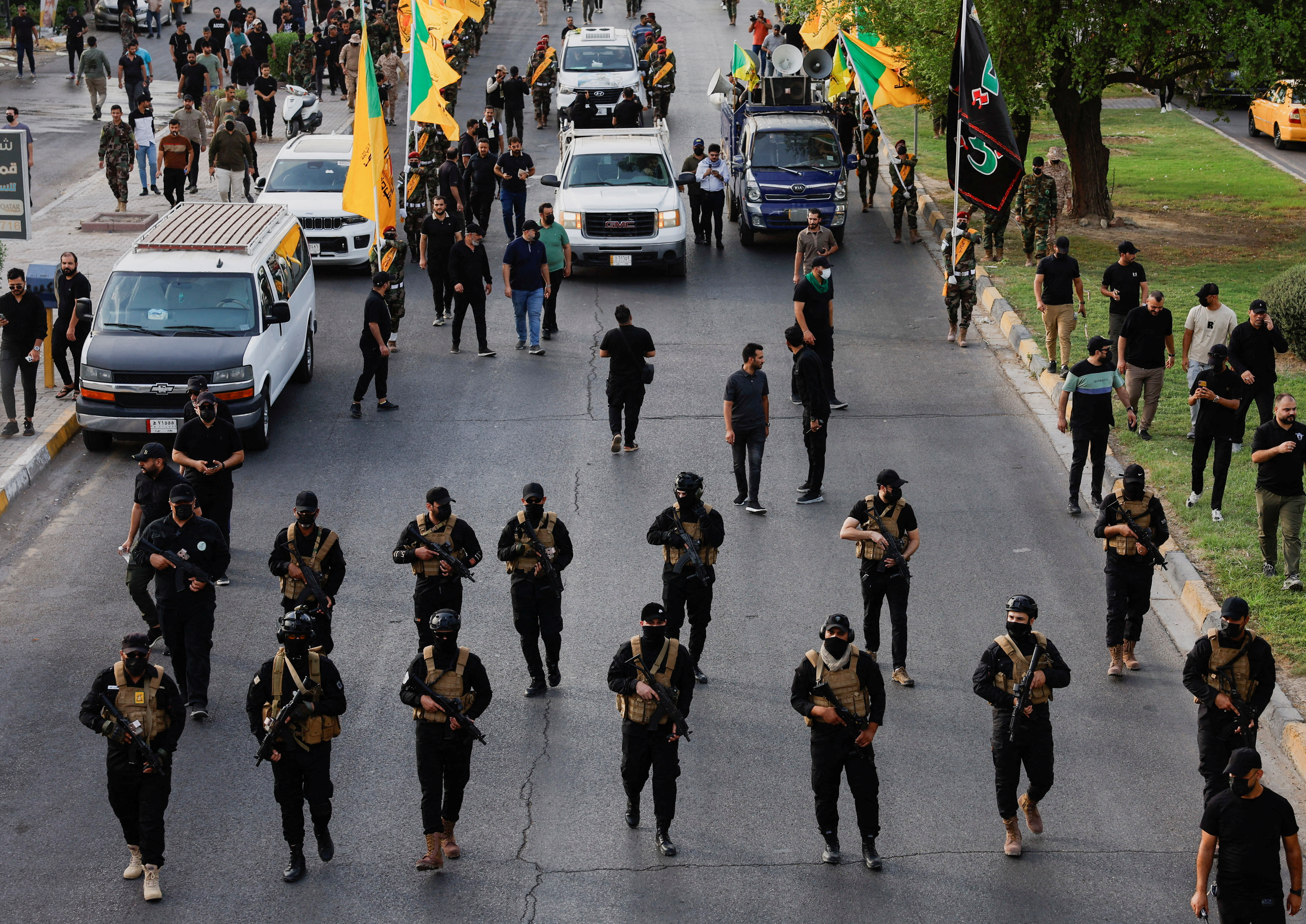 FILE PHOTO: A vehicle carries the coffin of a commander from Iraq's Kataib Hezbollah armed group, in Baghdad