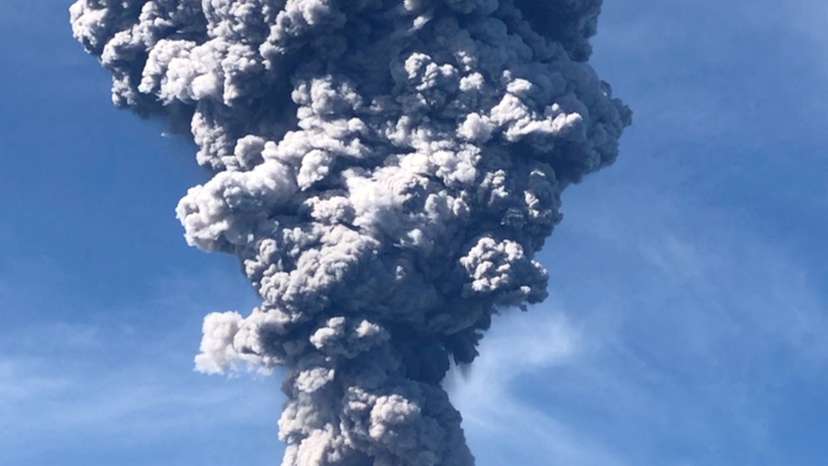 A column of ash rises over the Gunung Ibu volcano