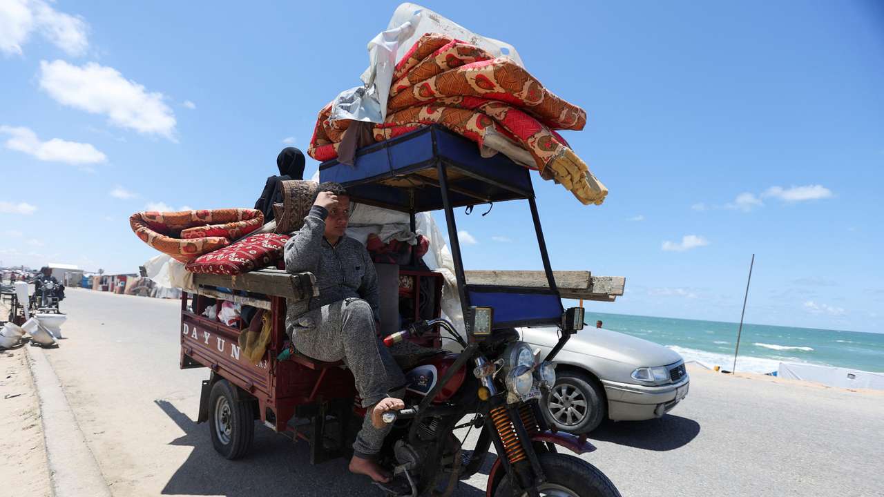 Displaced Palestinians who fled Rafah, ahead of a threatened Israeli assault, travel in Al-Mawasi area, in Khan Younis