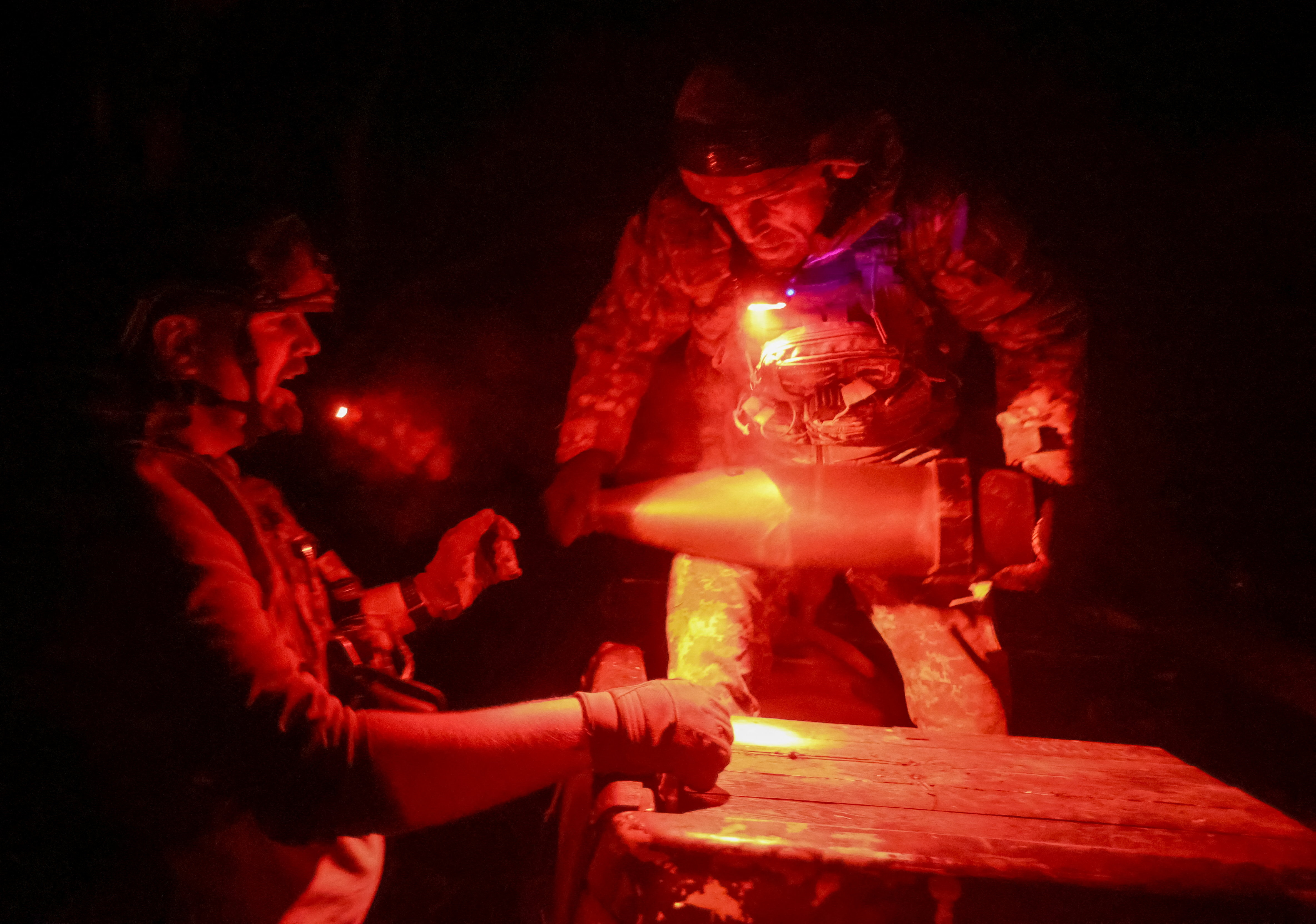 Ukrainian servicemen unload shells for a self-propelled howitzer near the frontline town of Pokrovsk