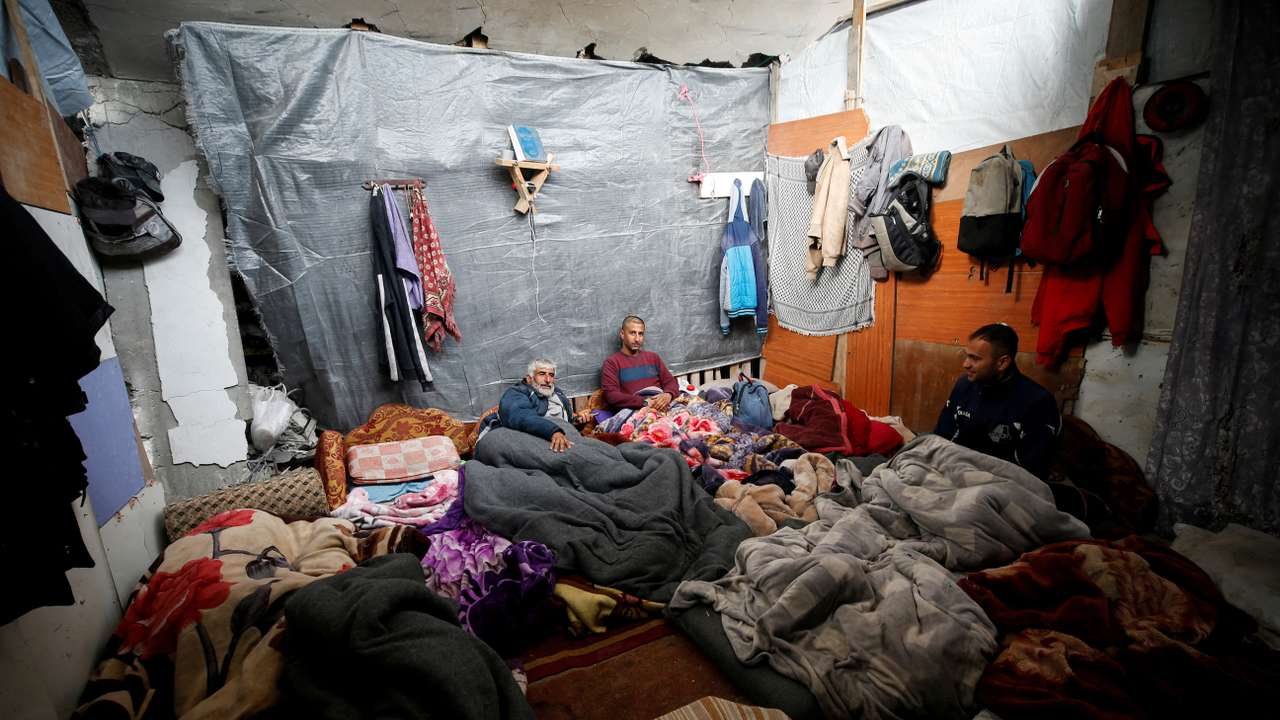 Palestinians take shelter at their ruined house, on a rainy day, amid a ceasefire between Israel and Hamas, in Jabalia refugee camp in the northern Gaza Strip