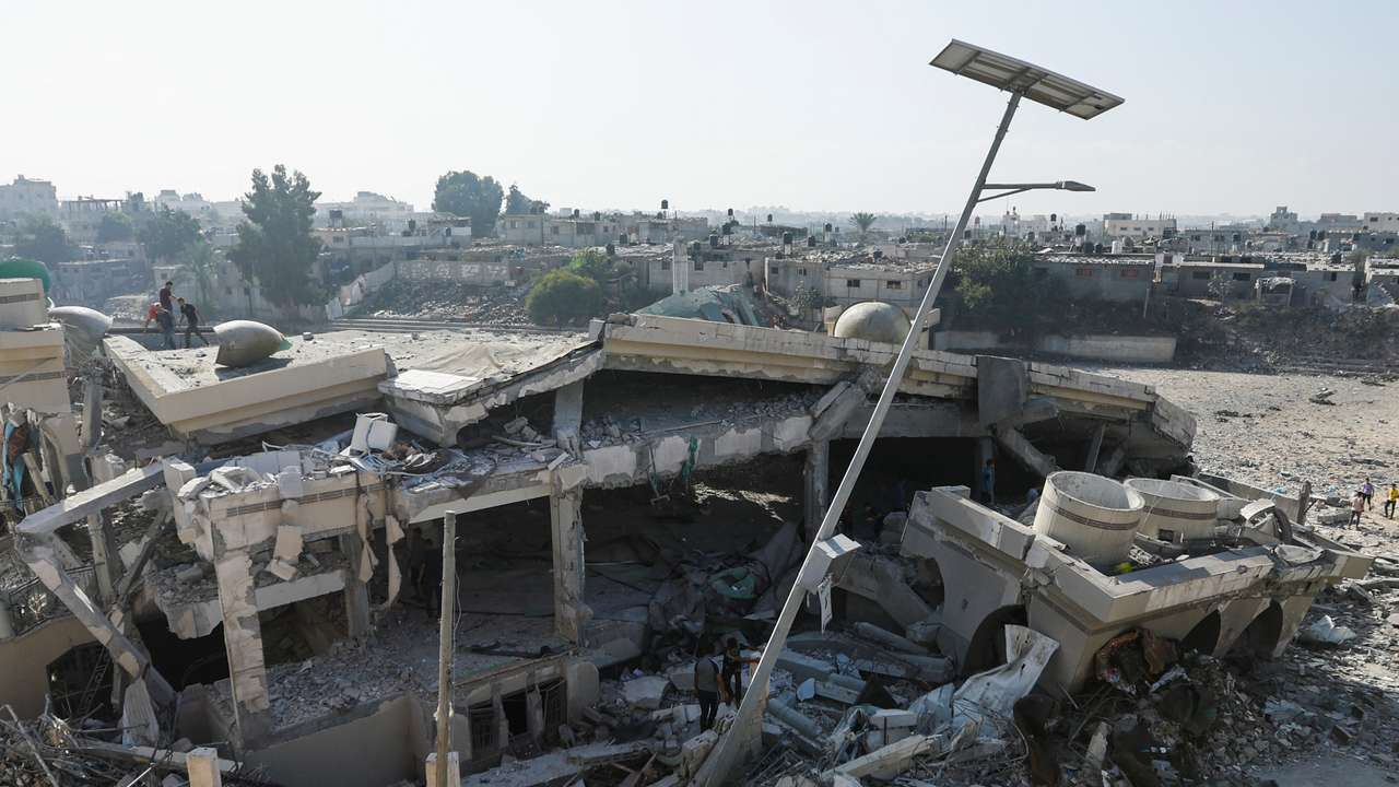 Palestinians inspect the site of an Israeli strike on a mosque in Khan Younis in the southern Gaza Strip