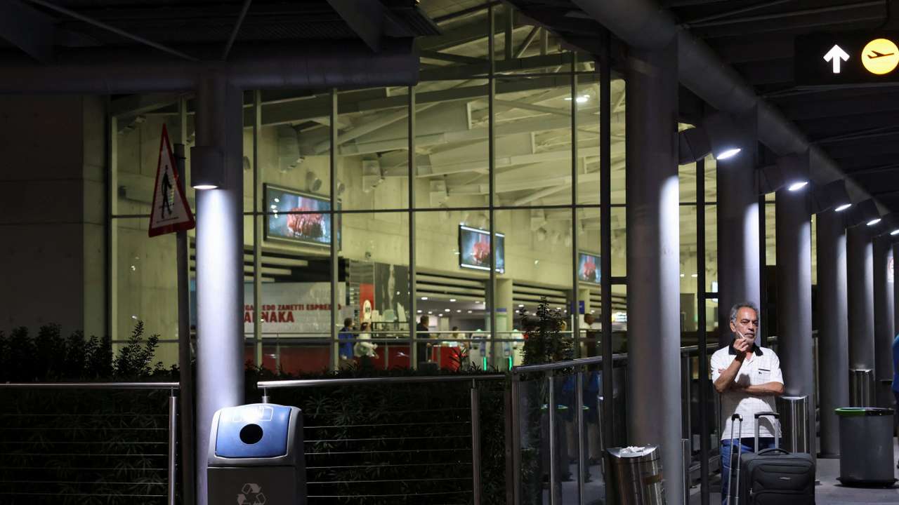Lebanese citizen Ali Abdul Hassan smokes a cigarette after arriving at Larnaca International Airport