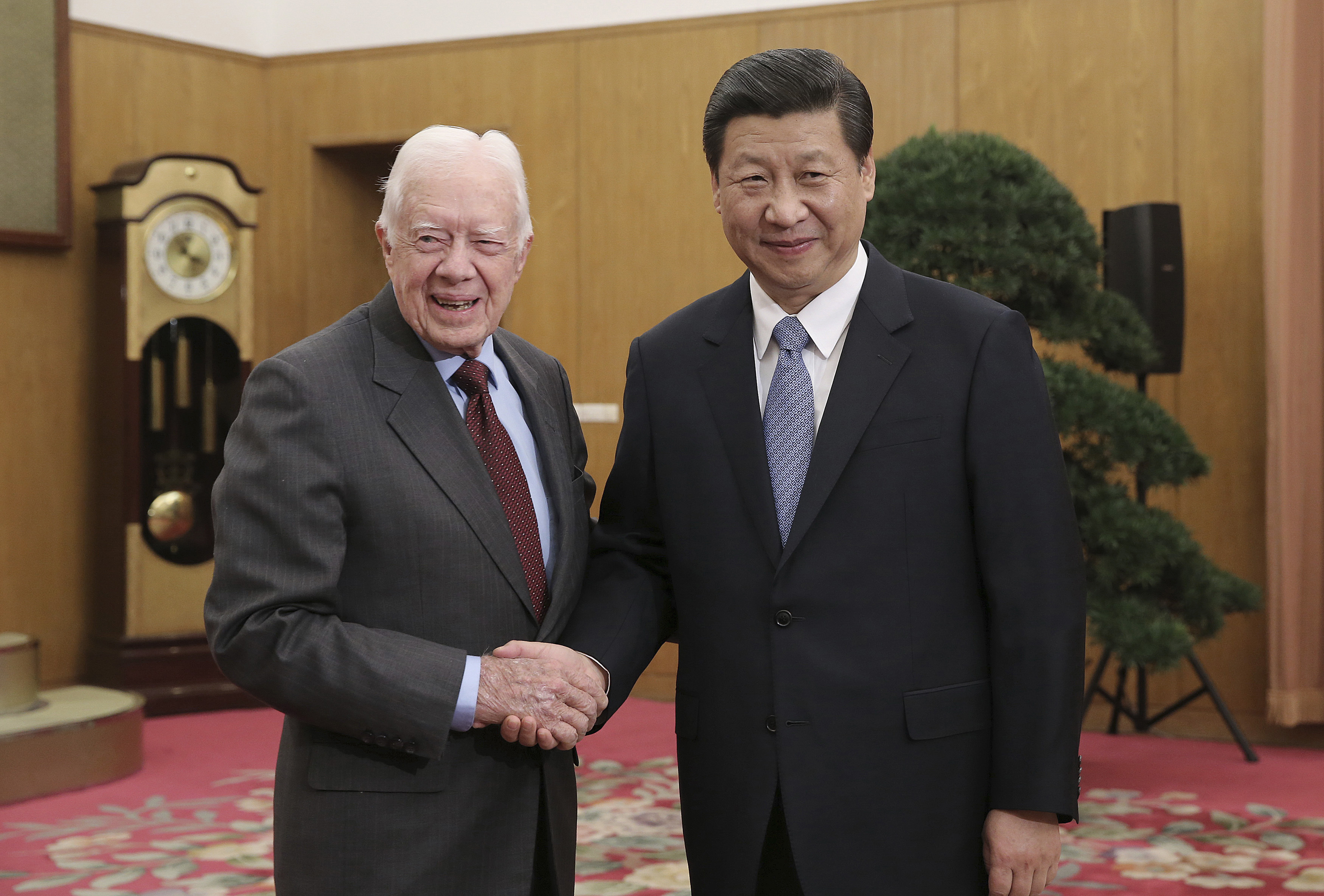 New leader of the Communist Party of China Xi Jinping shakes hands with former U.S. President Jimmy Carter during a meeting at Zhongnanhai, the central government compound in Beijing