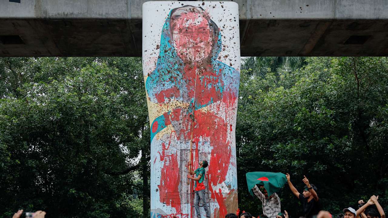 FILE PHOTO: Protesters shout slogans as they vandalise a mural of Bangladeshi PM Hasina with paint and mud, demanding her resignation at TSC area of University of Dhaka