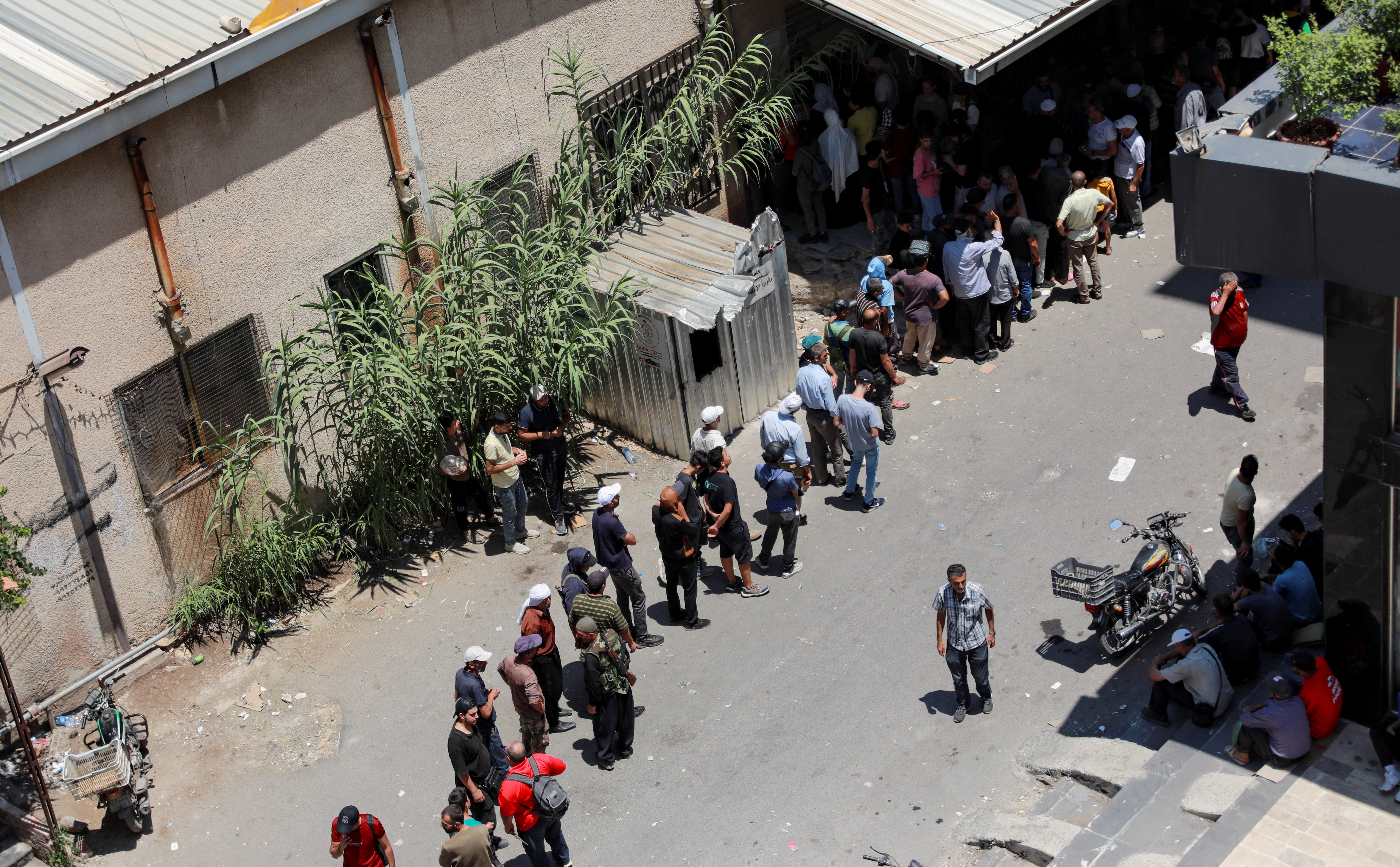 People queue to get bread in Sweida