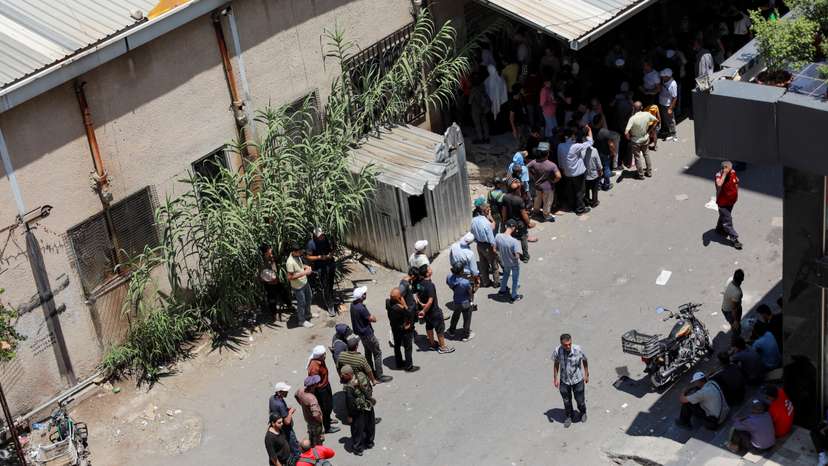 People queue to get bread in Sweida