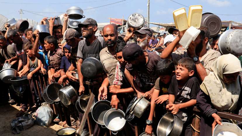 FILE PHOTO: Palestinians wait to receive food from charity kitchen in Khan Younis
