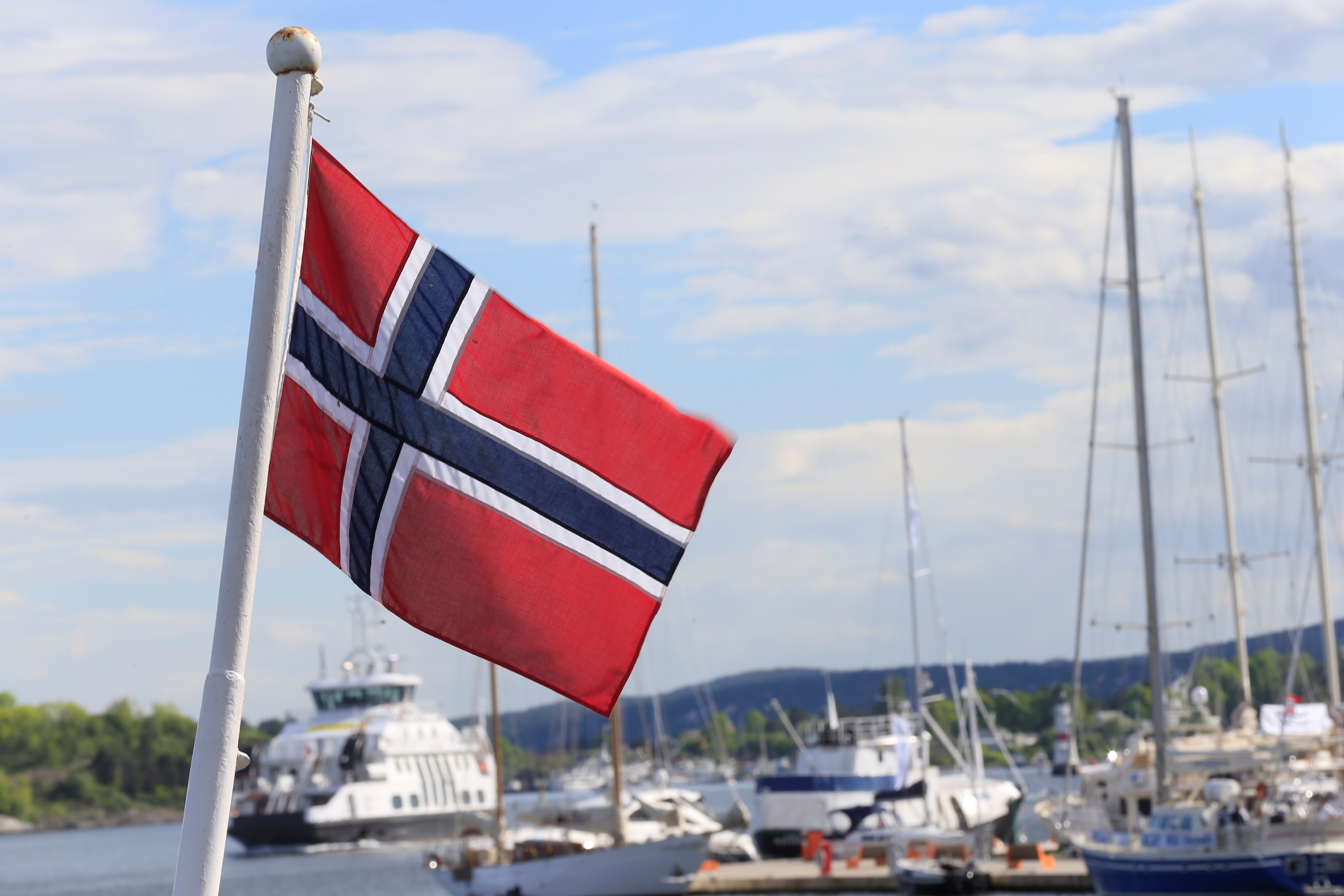 Norwegian flag flutters on the boat at Aker Brygge in Oslo