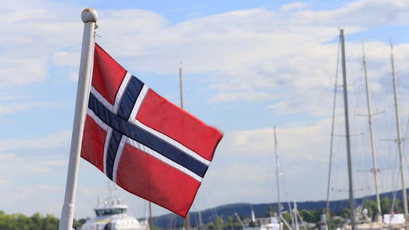 Norwegian flag flutters on the boat at Aker Brygge in Oslo