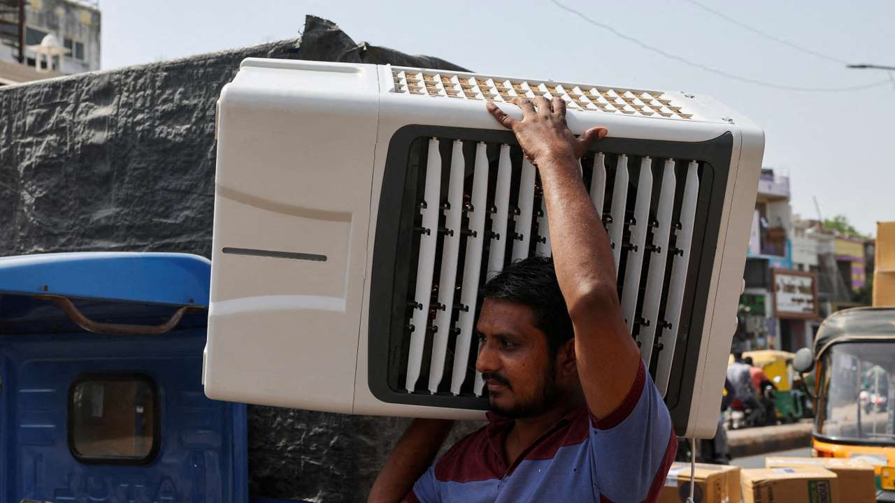 FILE PHOTO: FILE PHOTO: A worker carries an air cooler for delivery to a customer during the heat wave in Ahmedabad